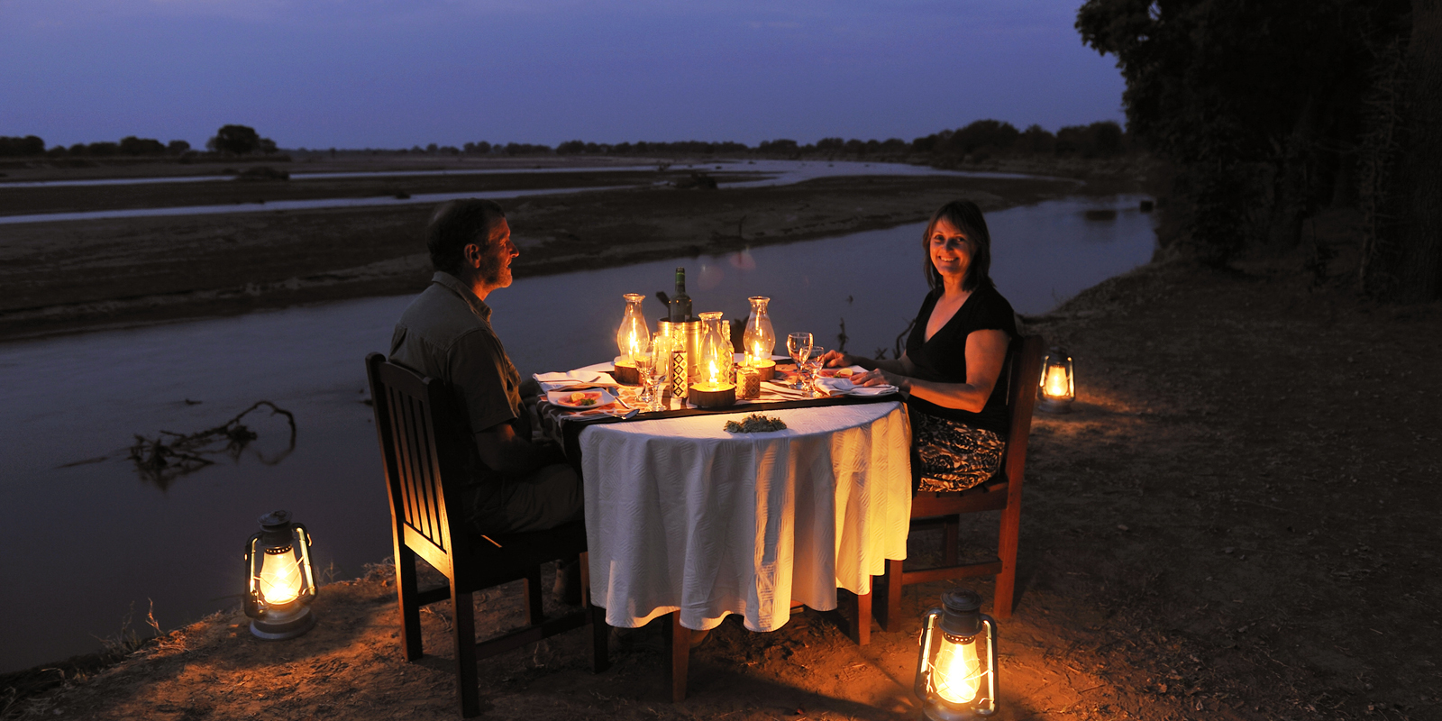 Romantic riverside dinner setting