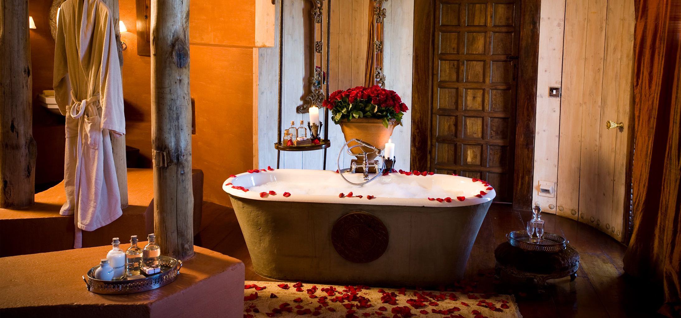 With a centrepiece of red roses has twin hand basins, shower, chandelierlit bathtub and seperate wc