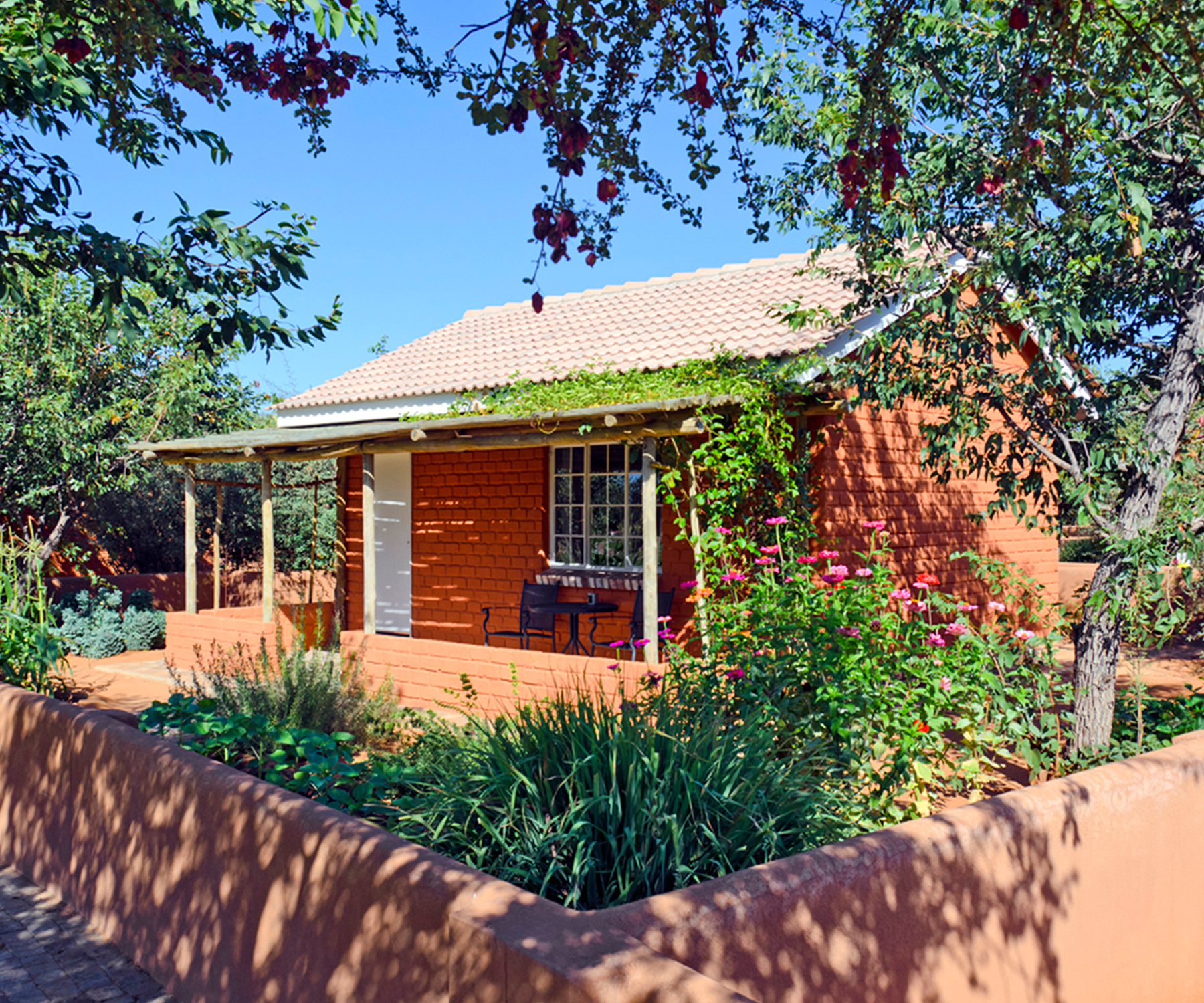 Each bungalow sits in a vegetable and herb garden surrounded by a low wall. 