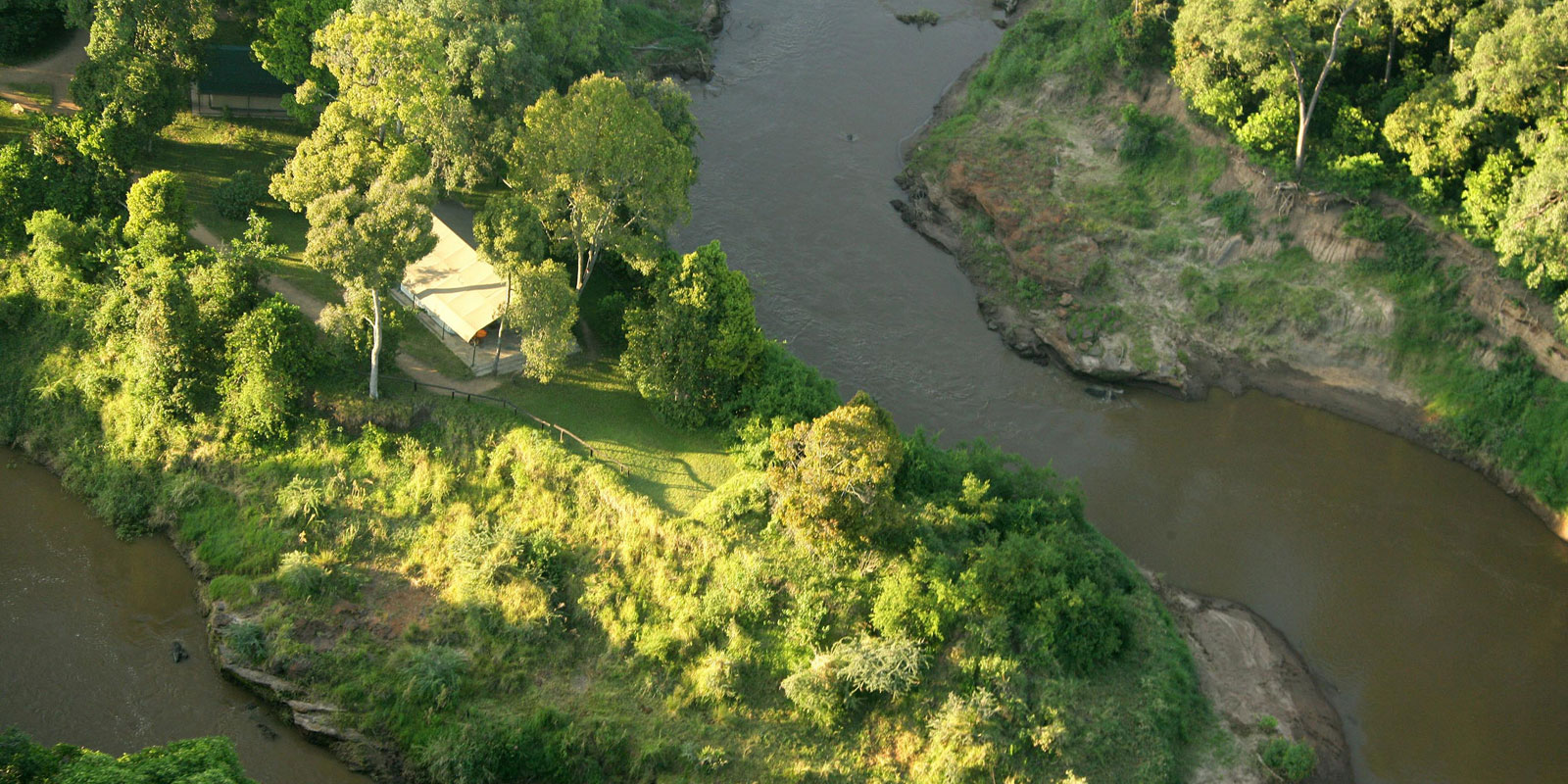 The Justus Suite tucked into a quiet bend in the Mara River where hippos wallow and elephant come to feed. 