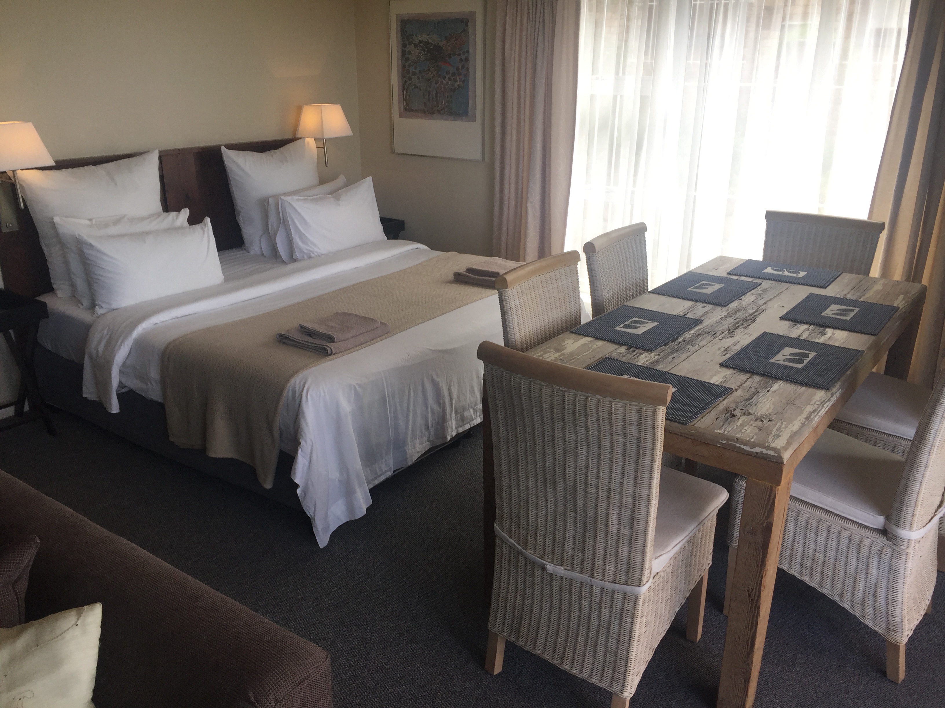 King bed in main bedroom with open plan dining and lounge area