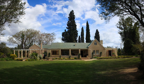 A 1930s colonial building set in a landscaped garden and surrounded by citrus plantations