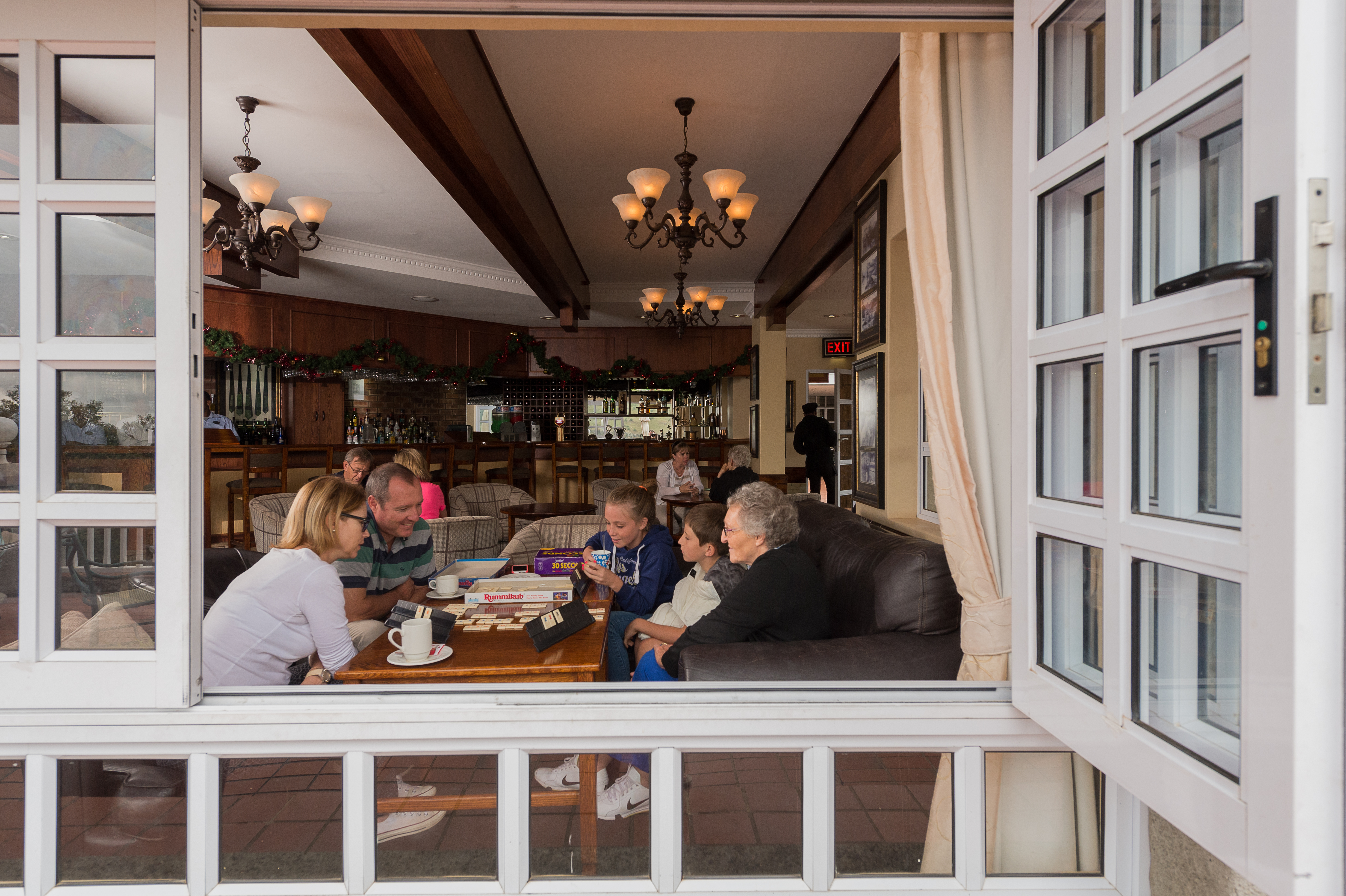 Family Enjoying the cosy Alberts Bar and escaping the rain outside