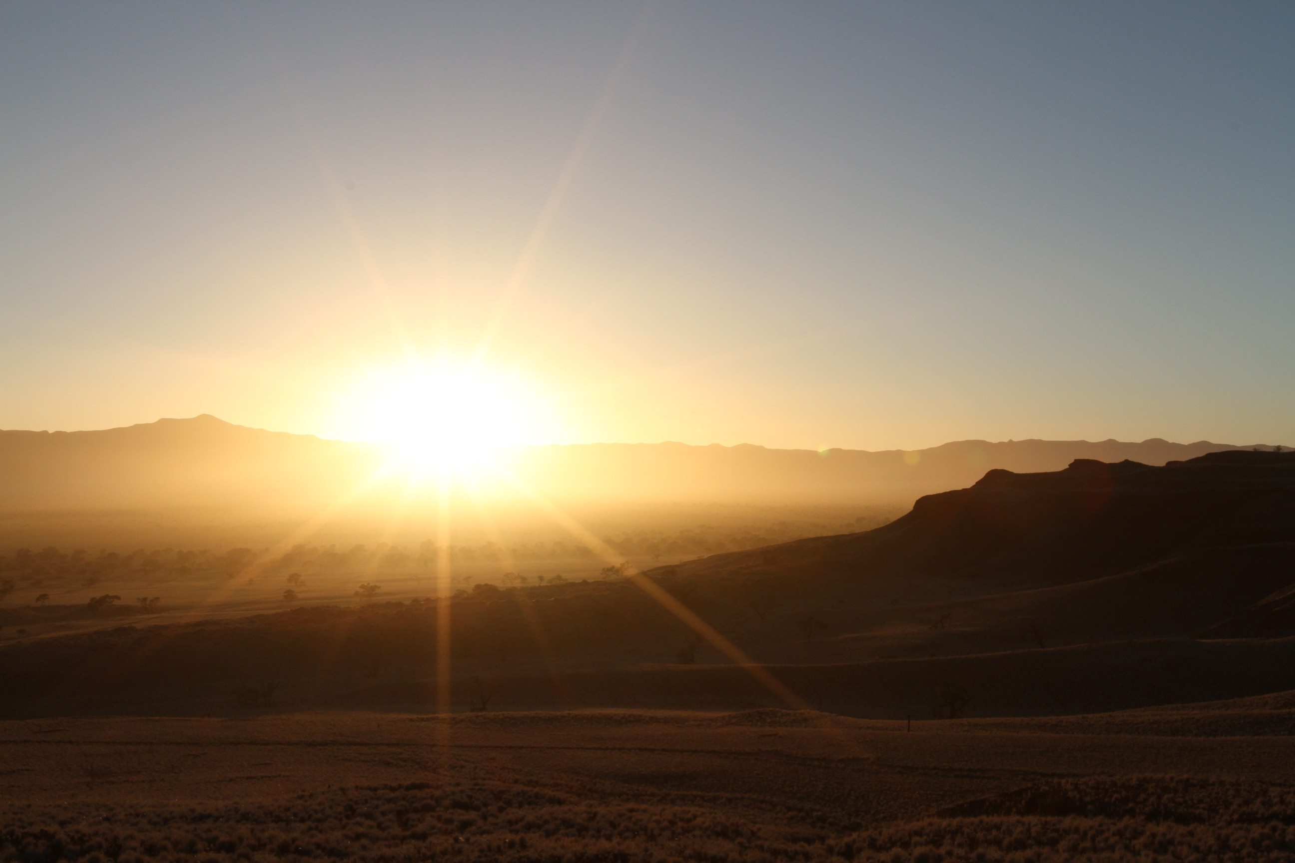 Watch the sun as it casts its rays over the desert 