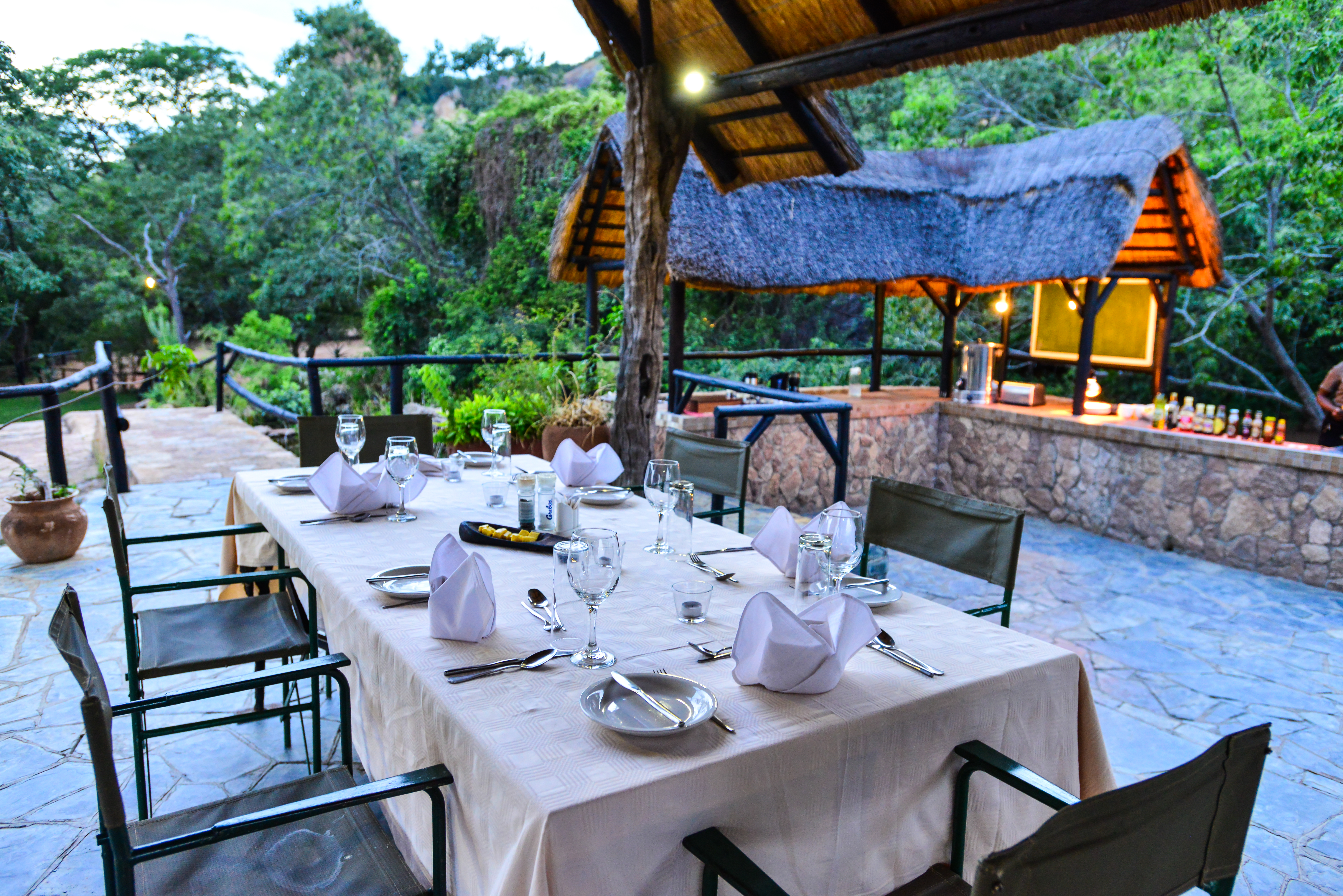 Guests enjoy meals under a thatch dinning area.