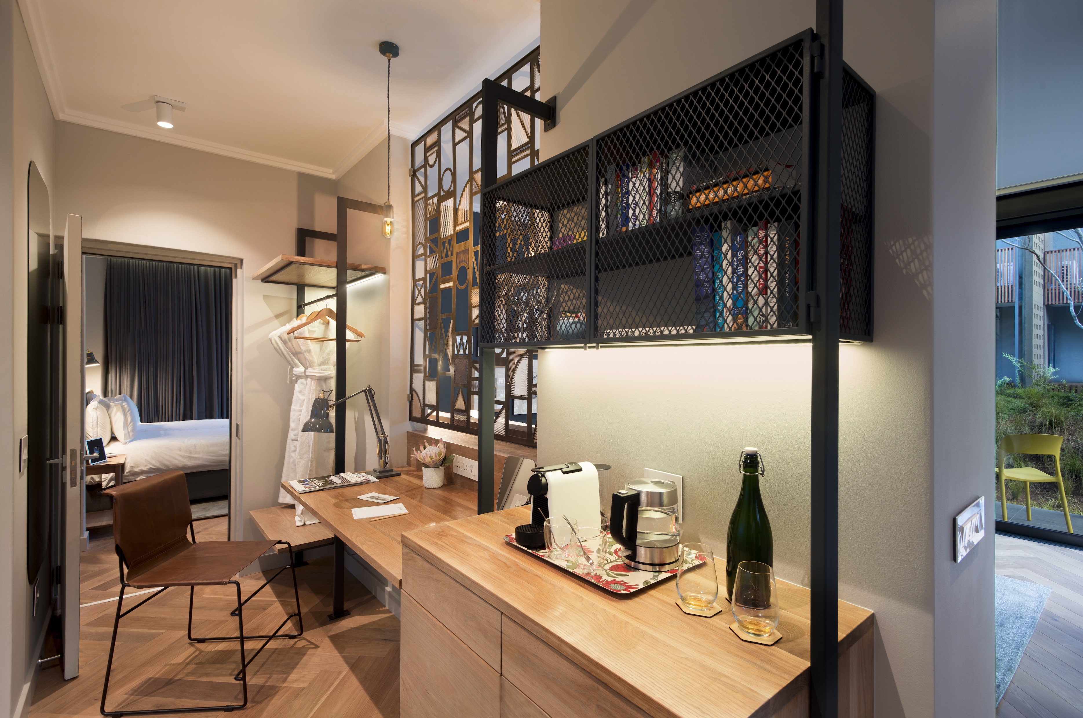 Desk and refreshment station including mini-bar fridge, tea and coffee making facilities, desk area with phone chargers and adaptors, open wardrobe