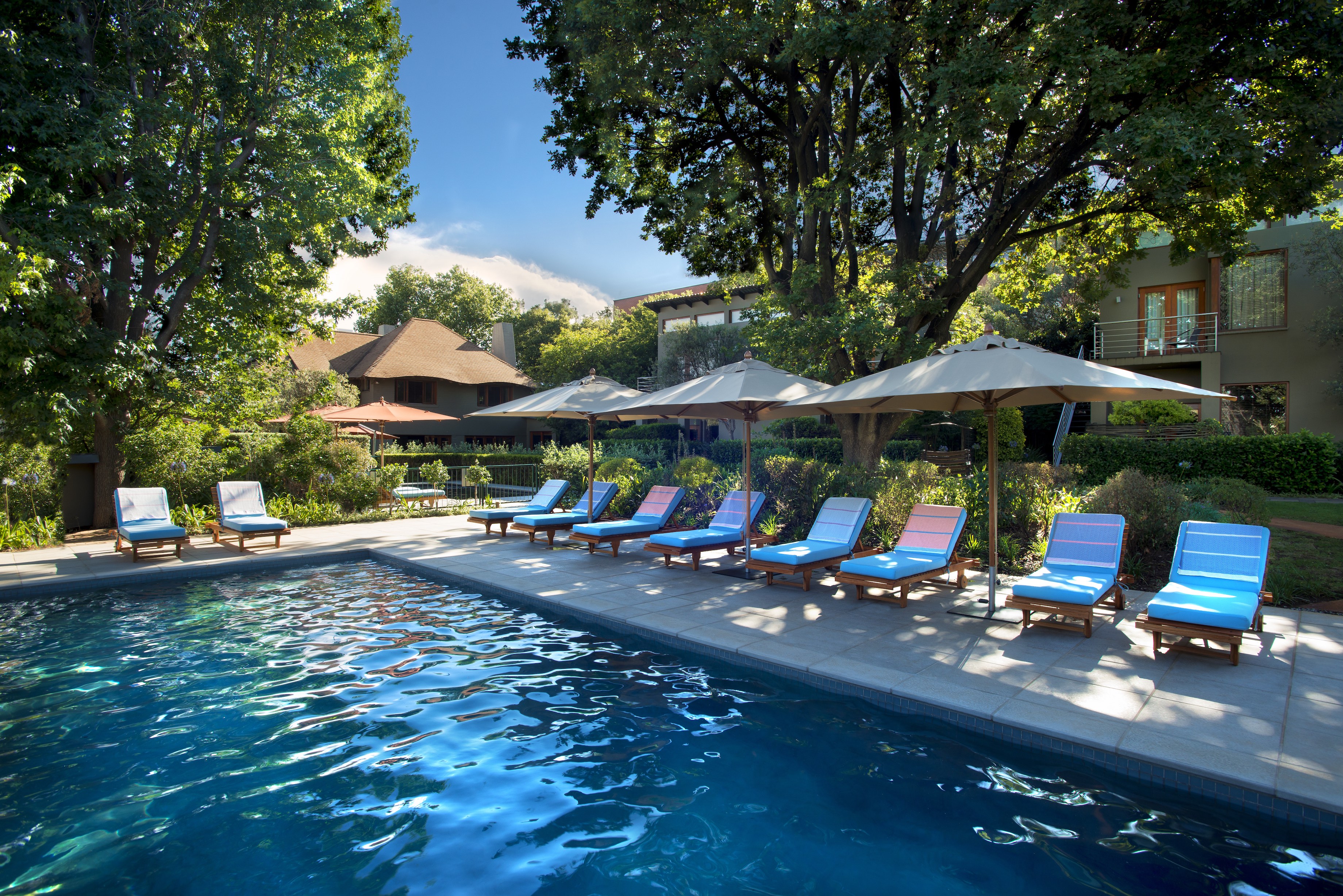 Larger lap pool with sun loungers and umbrellas
